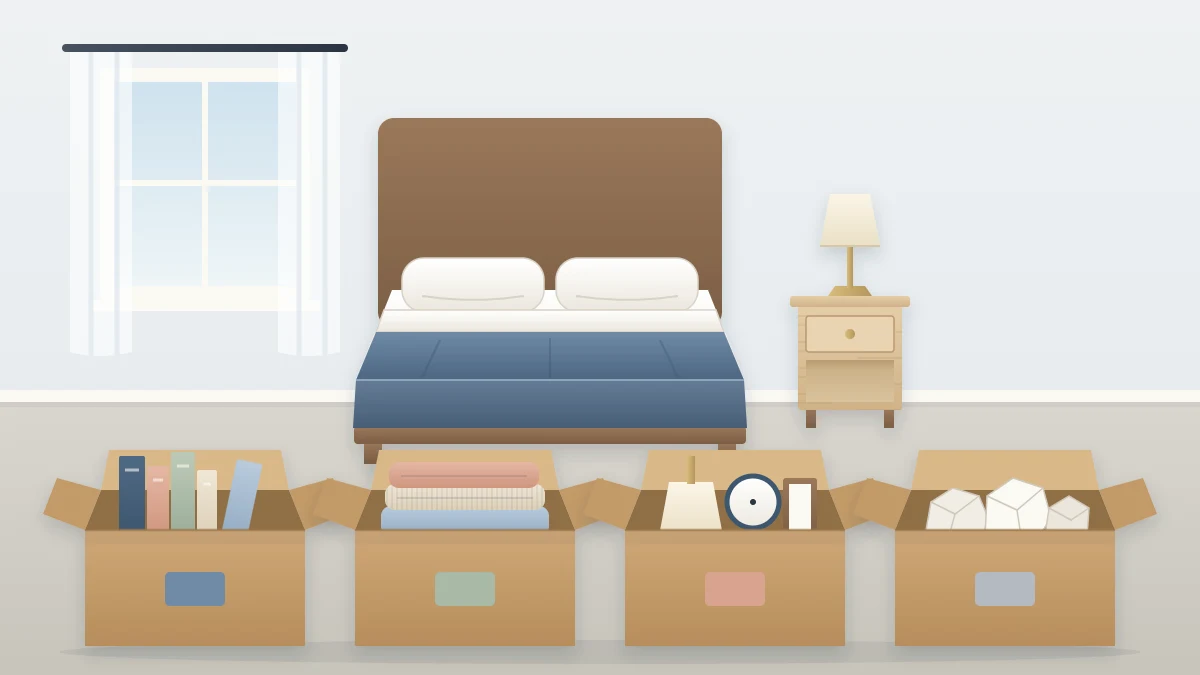 Four open boxes in a row on the floor at the foot of a bed, each partly filled with books, folded clothes and small objects, a cleared nightstand behind