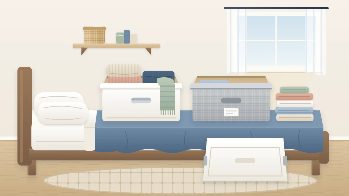 Two open storage boxes on a bed, one being packed with thick sweaters and a scarf, the other holding light T-shirts and shorts